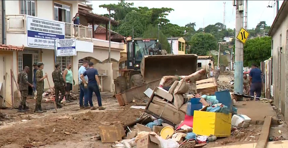 Restos de móveis, roupas e eletrodomésticos jogados nas calçadas após enchente em Apiacá, Espírito Santo — Foto: Reprodução/TV Gazeta