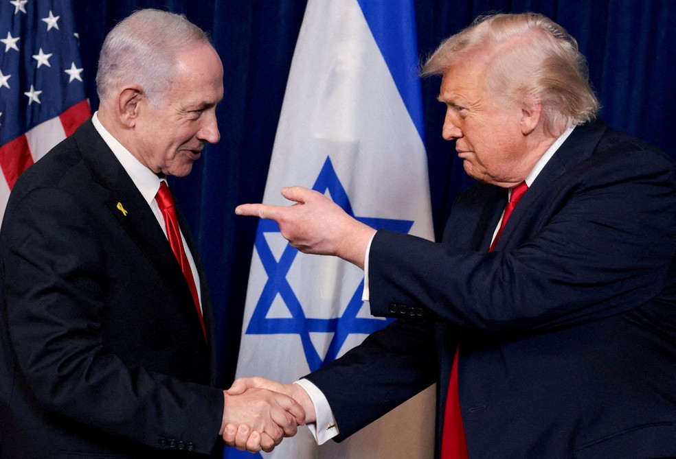 O presidente dos EUA, Donald Trump, aponta o dedo para o primeiro-ministro israelense, Benjamin Netanyahu, enquanto apertam as mãos durante uma coletiva de imprensa após reunião no clube Mar-a-Lago de Trump em Palm Beach, Flórida, EUA, em 29 de dezembro de 2025 — Foto: REUTERS/Jonathan Ernst