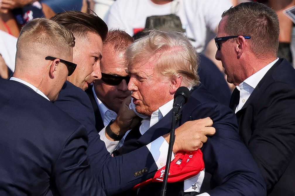 Donald Trump recebe proteção de seguranças após tiros em comício — Foto: REUTERS/Brendan McDermid