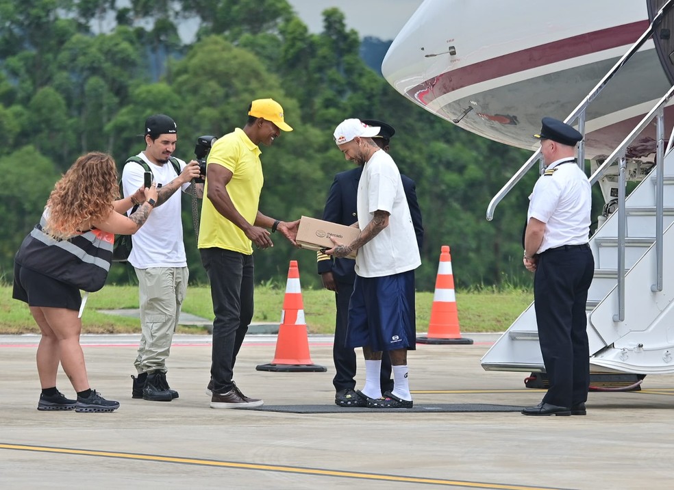 Neymar recebe presente ao desembarcar no Brasil em seu retorno ao futebol brasileiro — Foto: Leo Franco / AgNews