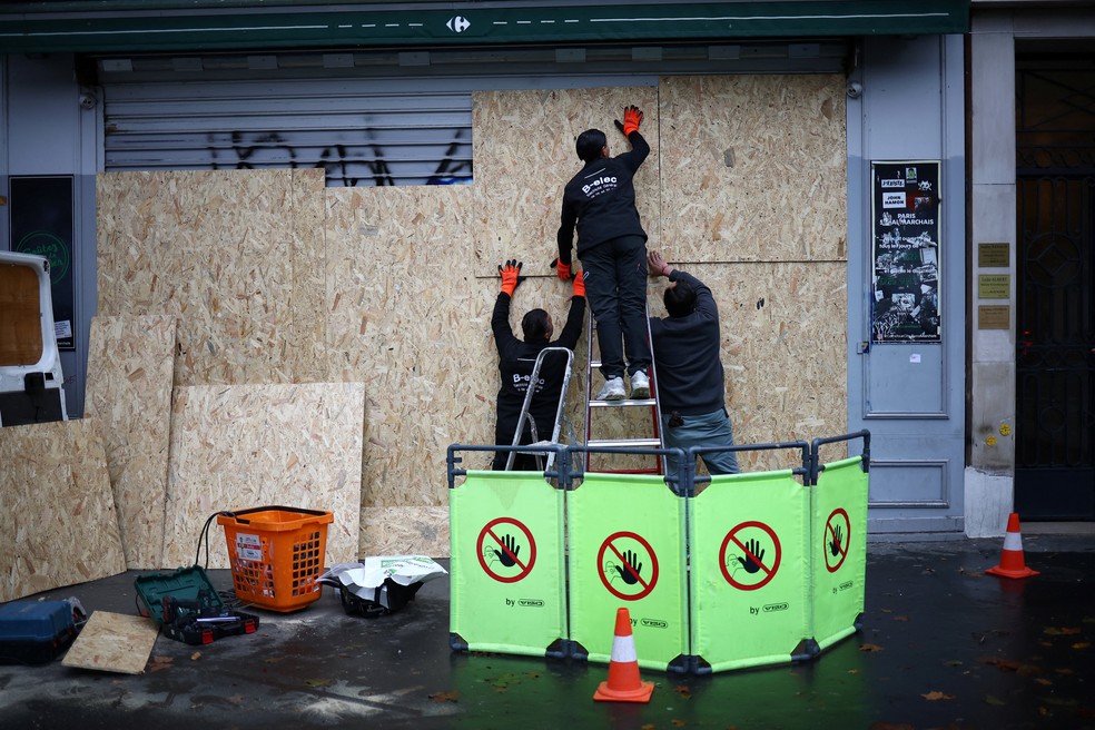 Barricada sendo montada na porta de loja &mdash; Foto: REUTERS/Pedro Nunes