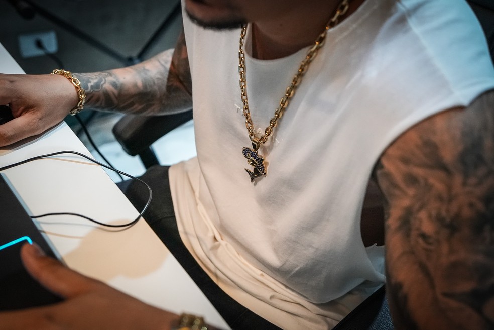 Japa NK tem um cordão de ouro com pingente que faz referência a MC Ryan SP, antes chamado de "tubarão do funk". — Foto: Fábio Tito/g1