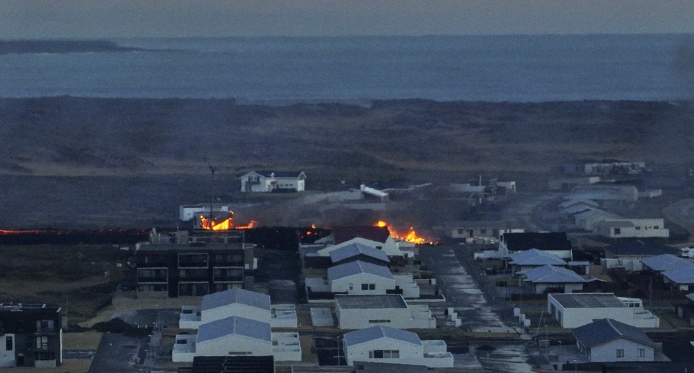 Casas são consumidas pelo fogo na cidade de Grindavik, no sudoeste da Islândia, após a erupção vulcânica deste 14 de janeiro. — Foto: Halldor KOLBEINS/AFP