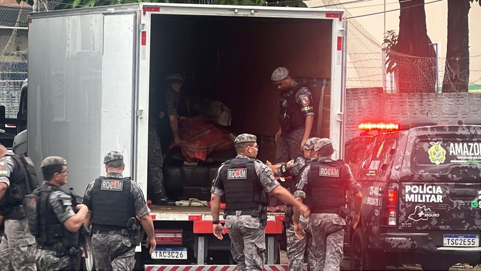 Policiais militares descarregam drogas apreendidas nesta quinta-feira (26). — Foto: Karla Mendes/Rede Amazônica