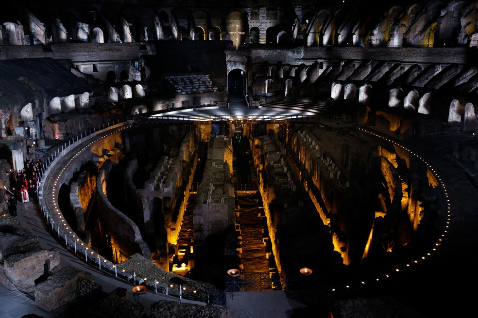 O papa Leão XIV (à esquerda, de vermelho) preside a procissão da Via Crucis no Coliseu, em Roma, Itália — Foto: Remo Casili/Reuters