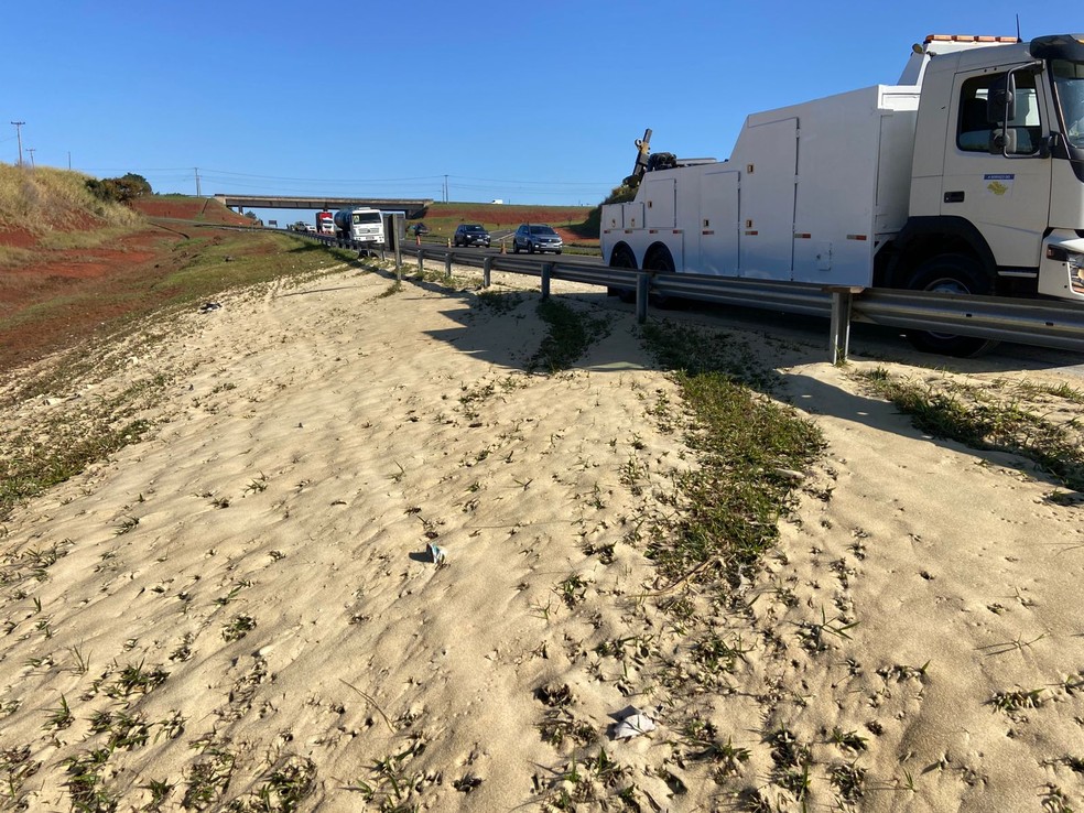 O suporte do caminhão teria quebrado, fazendo com que caçamba tombasse na pista e a carga ficasse espalhada no acostamento. — Foto: Edijan Del Santo/EPTV