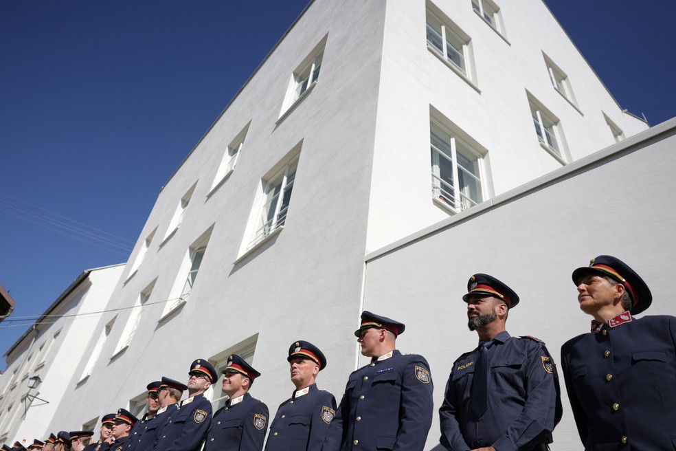 Policiais em frente a nova delegacia, feita em edifício onde Adolf Hitler nasceu, durante cerimônia de inauguração em Braunau am Inn, na Áustria, 22 em julho de 2026. — Foto: REUTERS/Gintare Karpaviciute
