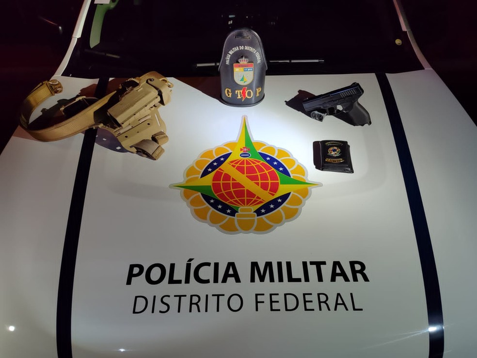 Falso policial preso pela PM portava simulacro de arma de fogo, coldreada de forma ostensiva em um cinto tático, além de uma carteira com brasão da "Polícia Militar" — Foto: PMDF/Divulgação