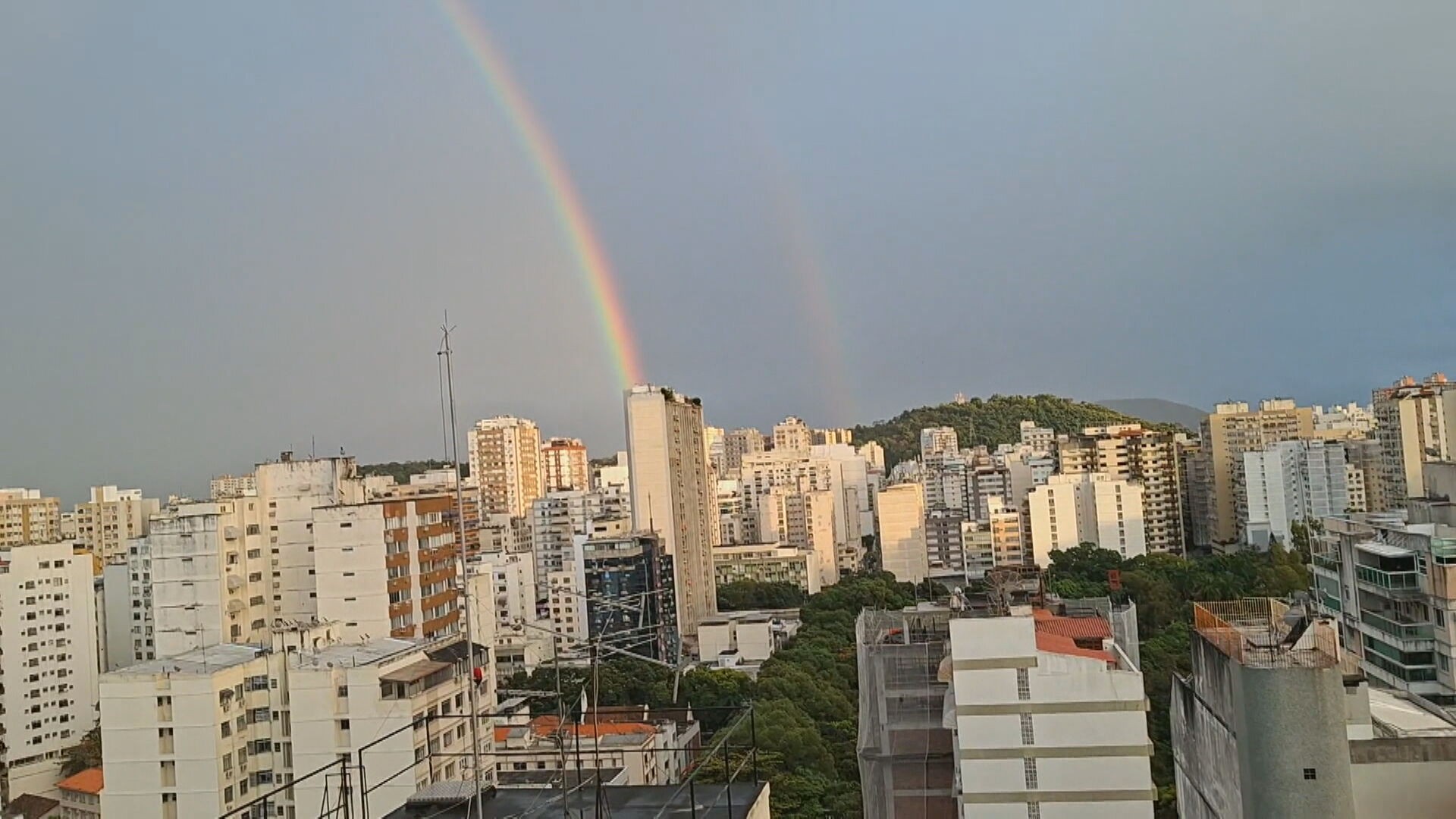 Semana começa com tempo instável no Rio; alternância entre sol e chuva faz arco-íris aparecer no céu