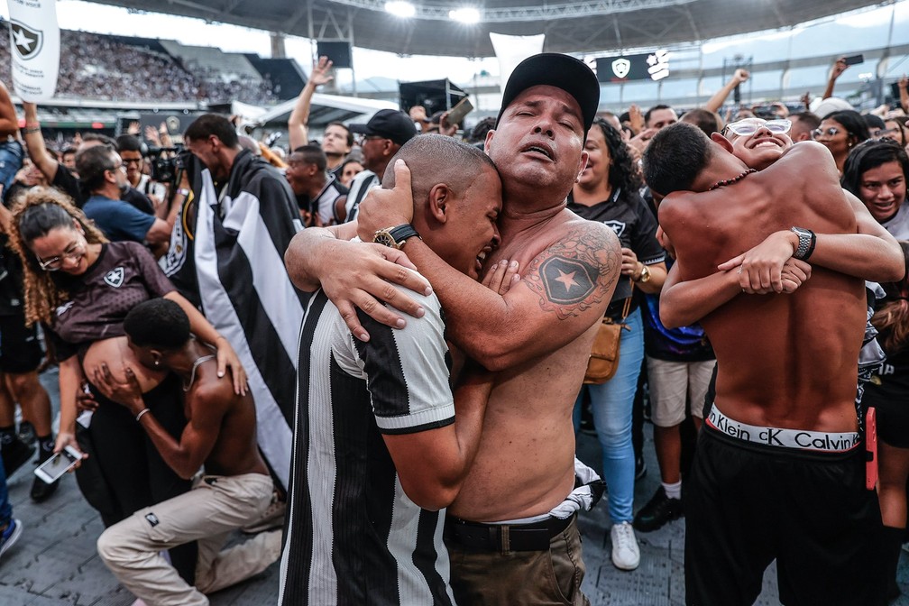 Torcedores do Botafogo se abraçam e beijam comemorando a vitória do time sobre o Atlético Mineiro na final da Libertadores da América, em transmissão do jogo em Buenos Aires feita em telões no Engenhão, estádio do Botafogo, no Rio de Janeiro. Imagem foi uma das vencedoras na categoria de fotos individuais da América do Sul — Foto: André Coelho/EFE via World Press Photo/Divulgação