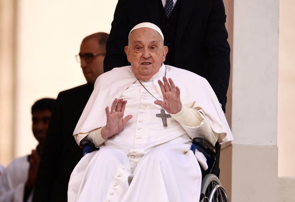 O Papa Francisco acena ao aparecer inesperadamente durante a missa do Domingo de Ramos na Praça de São Pedro, no Vaticano — Foto: REUTERS/Yara Nardi