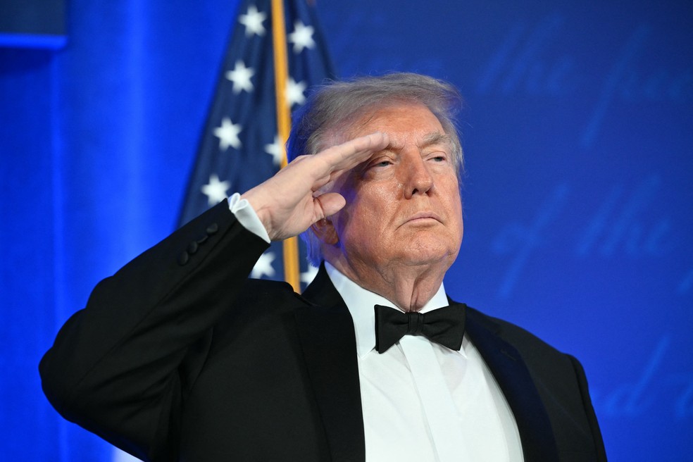 O presidente dos Estados Unidos, Donald Trump, batendo continência no início do jantar promido pela Casa Branca aos jornalistas correspondentes internacionais. — Foto: Mandel Ngan / AFP