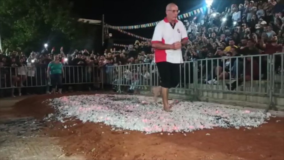 Lúcio faz a travessia na brasa da fogueira em Bocaina — Foto: Yonny Furukawa/TV TEM