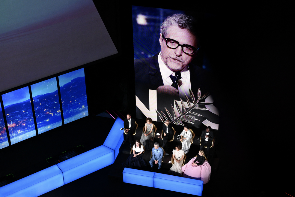 O júri do 78º Festival de Cinema de Cannes observa o diretor brasileiro Kleber Mendonça Filho receber o prêmio de Melhor Diretor pelo filme "O Agente Secreto" durante a cerimônia de encerramento da 78ª edição do Festival de Cinema de Cannes, em Cannes, sul da França, em 24 de maio de 2025. — Foto: Antonin THUILLIER / AFP